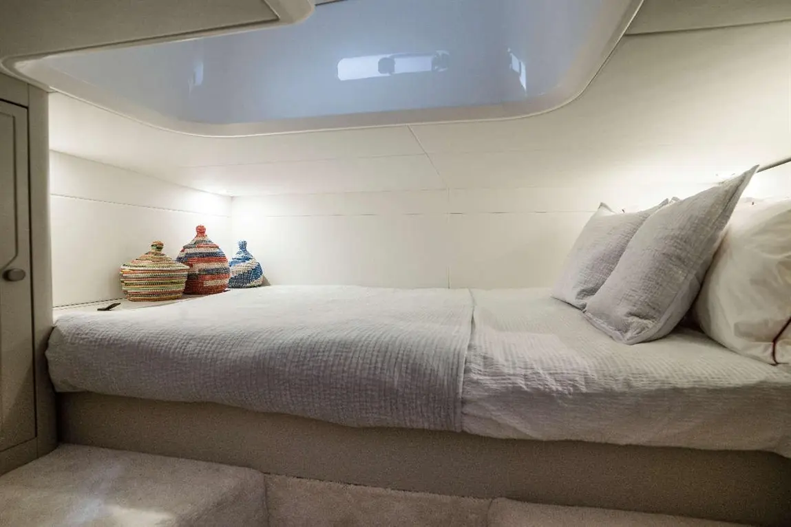 A minimalistic bedroom featuring a double bed with white linens and three decorative woven pots on the bedside.